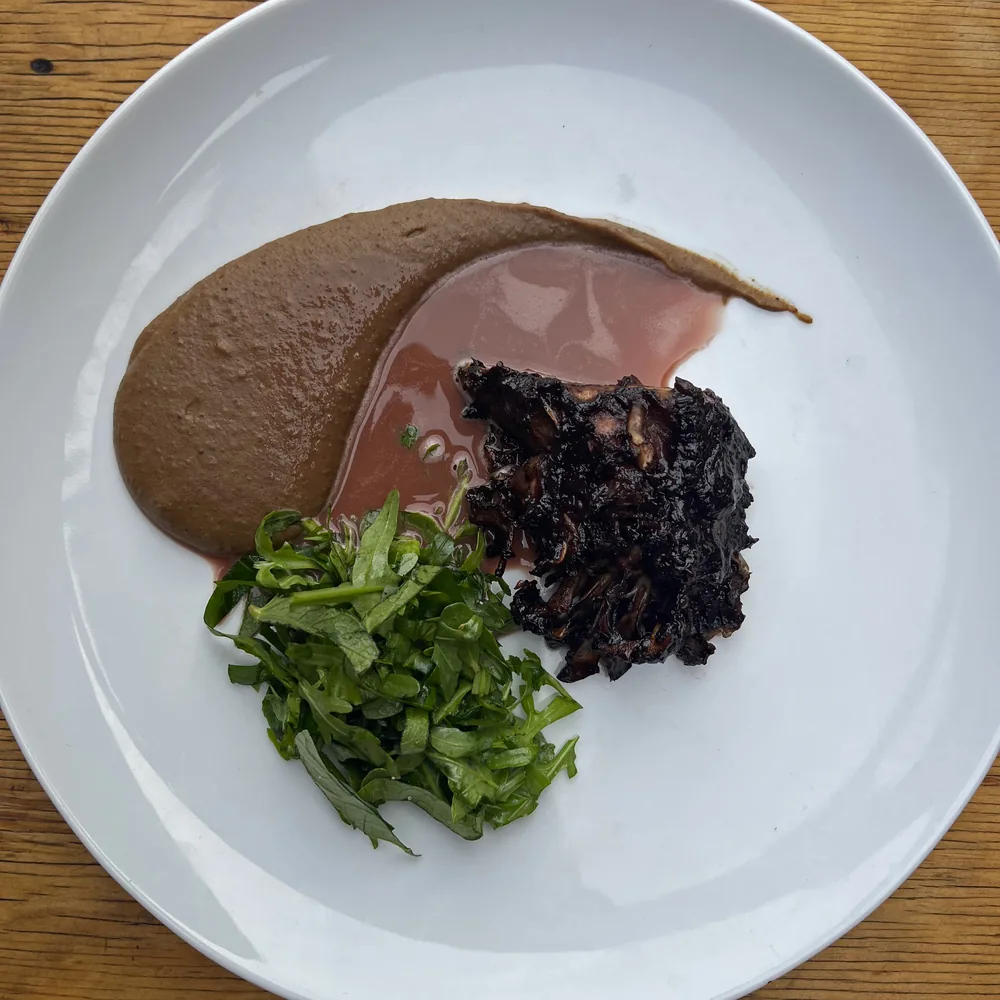 Gerecht met paddenstoel, puree en verse kruiden uit het voedselbos